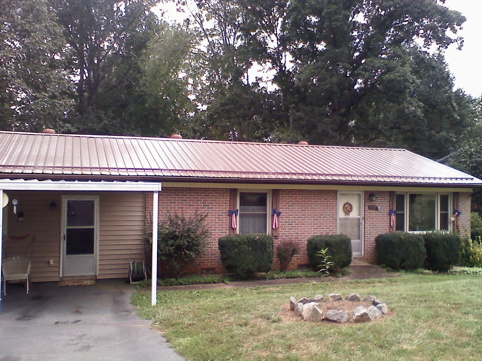Bronze metal roof and carport on a brick ranch home — Roof Repair work by our crew in Mineola